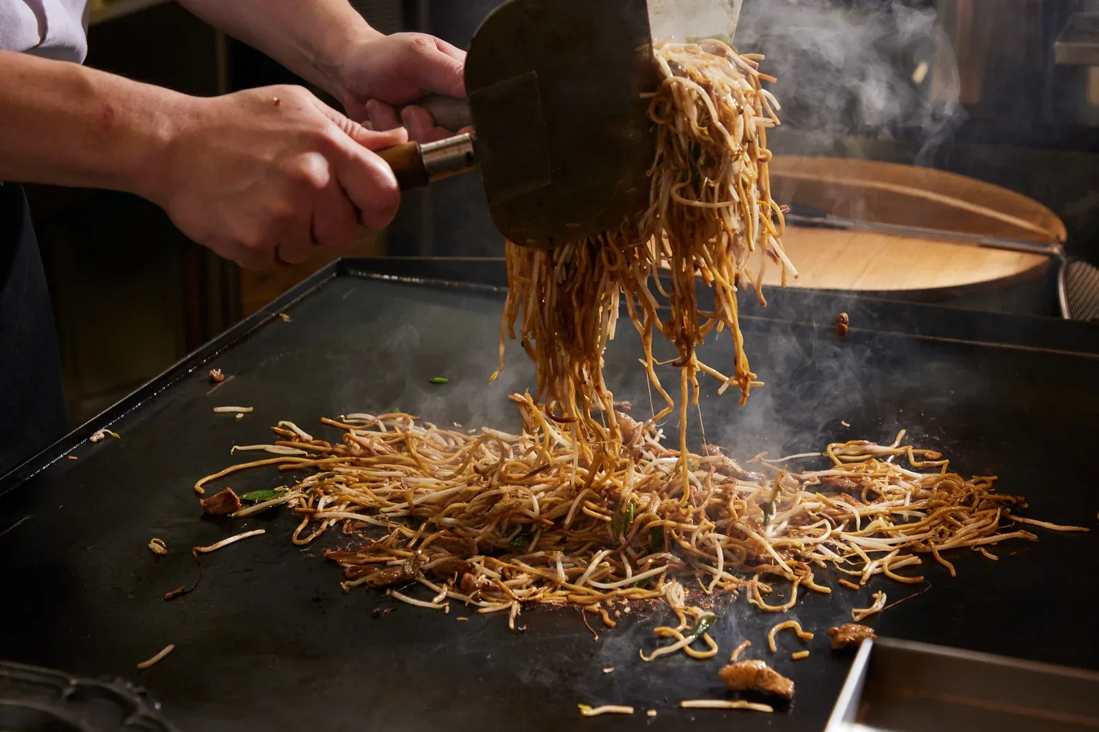 鉄板で焼きそばを焼き上げる